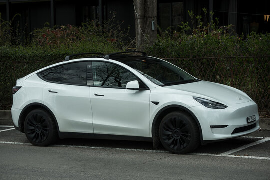 Basel - Switzerland, 24 march 2025 - profile view of white tesla car model 3 parked in the street 