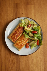 Fried flapjacks with chicken and salad of greens, cucumber, tomato and pumpkin seeds