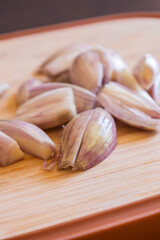  shallot onions on wooden cutting board close-up