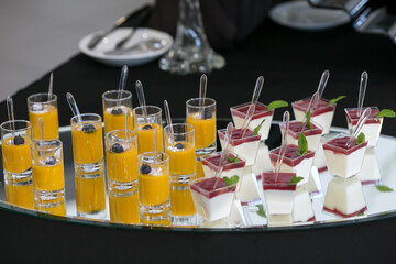 A tray of small desserts arranged beautifully with spoons