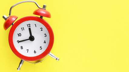 Red alarm clock on a yellow background
