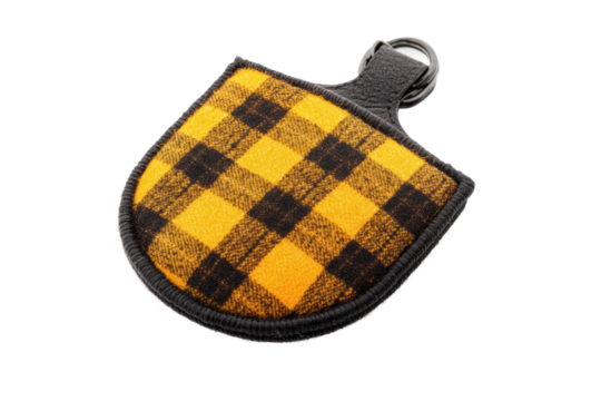 Yellow and black plaid fabric keychain with leather strap and metal ring, cut out - Powered by Adobe