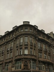 A historic multi-story building with a curved façade and ornate architectural details.