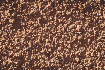 Intricate texture of sunbaked adobe wall reminiscent of traditional architecture in a warm desert landscape during a bright afternoon