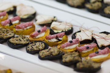 A pristine white plate beautifully topped with a variety of appetizers
