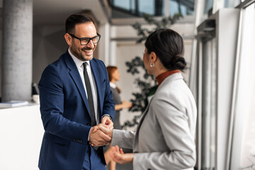 Professional Business Colleagues Shaking Hands in Modern Office Setting