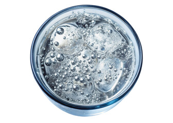Closeup overhead view of sparkling water with ice cubes in a glass on black background showing bubbles and reflections