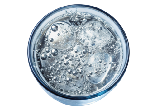 Closeup overhead view of sparkling water with ice cubes in a glass on black background showing bubbles and reflections