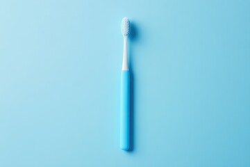 A light blue toothbrush against a light blue background.  The toothbrush features a light colored bristle head and a light blue handle