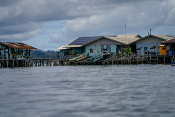 Close view of boats docked at solar-powered stilt houses in a tropical village