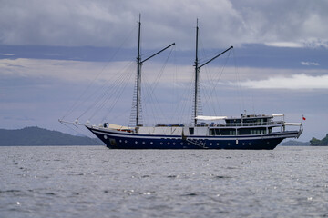 Close-up of schooner sailing boat anchored in tropical sea near island coast