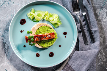 Cod fillet fried with spinach and broccoli and cauliflower puree sauce on a blue plate. The concept...