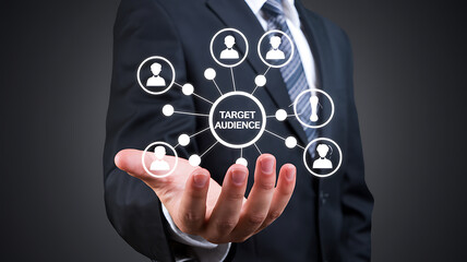 Businessman's open palm presents a target audience network diagram symbolizing marketing and customer reach.