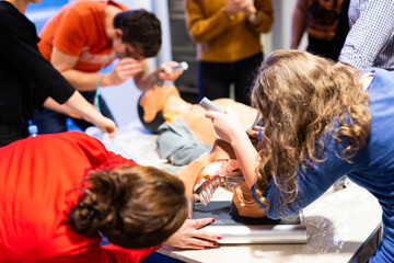 Medical doctor expert instructor displaying method of patient intubation on medical education training and workshop. Participants working in teams learning new medical procedures and techniques.