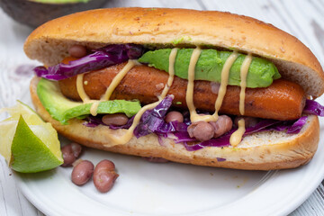 Vegan hot dogs made with carrot served in buns with beans, avocado and pickles
