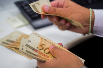 Businessman counting and exchanging money - Brazilian Real - Reais.