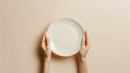 A person is holding a plate with a white rim. The plate is empty and the person is holding it up to the camera. Concept of emptiness and simplicity