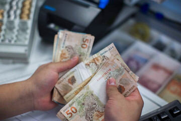 Businessman counting and exchanging money - Brazilian Real - Reais.