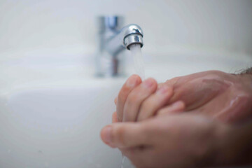 Close up of human hand washing hand on sink.