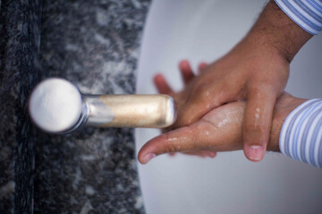 Close up of human hand washing hand on sink.