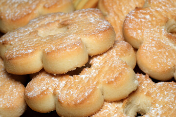 Sweet floral cookies dusted with powdered sugar delightfully arranged on a platter
