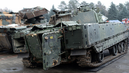 Military vehicle on display at a defense exhibition in a city park during daytime showcasing advanced technology and design