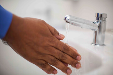 Close up of human hand washing hand on sink.