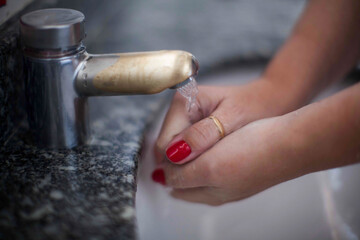 Close up of human hand washing hand on sink.
