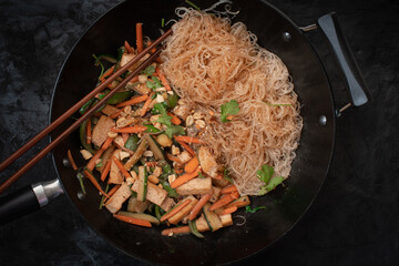 Vegan vegetables and tofu stir fry with bean thread noodles served in wok