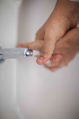 Close up of human hand washing hand on sink.