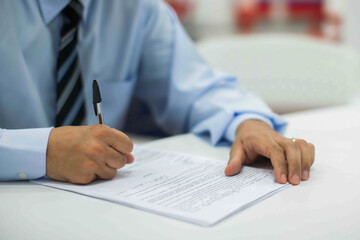 Crop shot of a business person with pen signing document