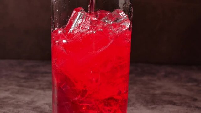 Red soda drink with ice cubes, Close up of soda fizzy drink in Cold glass, macro of red soft drink 