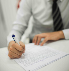 Crop shot of a business person with pen signing document