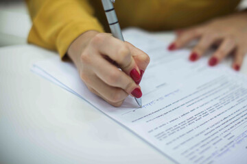 Crop shot of a business person with pen signing document