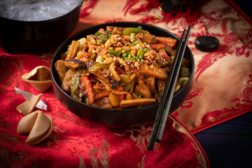Traditional Chinese Buddha's Delight stir fry for New Year  served in black bowl on traditional red fabric cover