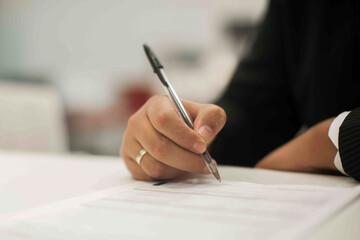Crop shot of a business person with pen signing document
