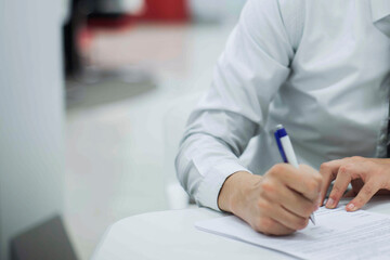 Crop shot of a business person with pen signing document