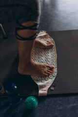 Feet standing on an acupressure mat for relaxation and pain relief. Alternative medicine, reflexology, and acupuncture therapy concept