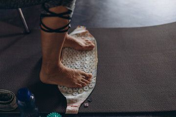 Feet standing on an acupressure mat for relaxation and pain relief. Alternative medicine, reflexology, and acupuncture therapy concept