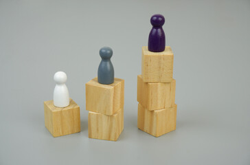 Ranking people concept. People figures on wooden cubes on gray background.
