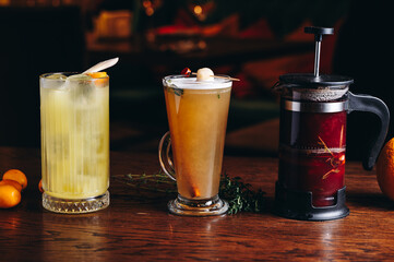 Three different beautiful cocktails in warm colors on a flower background