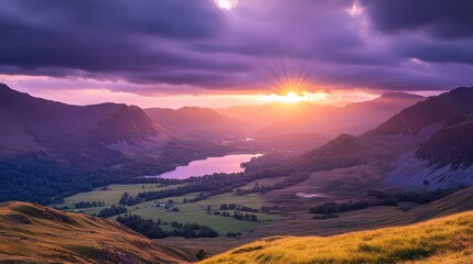 The sun setting behind a distant mountain range, casting a warm golden light on the valleys below, as the sky transforms into deep purples and blues.