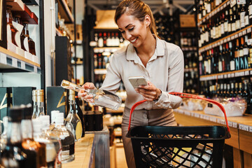 Beautiful young and elegant woman buying some healthy food and drink in modern supermarket or grocery store. Lifestyle and consumerism concept.