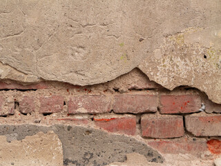 Exposed red brick wall with crumbling plaster and aged texture, perfect for backgrounds, architectural details, restoration themes, or vintage design elements