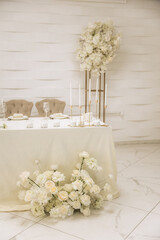 Wedding decoration in a restaurant. White flowers, serving and decor for a wedding