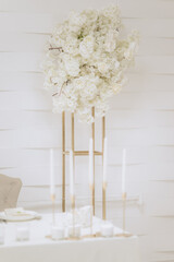 Wedding decoration in a restaurant. White flowers, serving and decor for a wedding