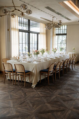 Decorated table with fresh flowers and serving with postcard. Celebrating a party in a restaurant