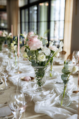 Decorated table with fresh flowers and serving with postcard. Celebrating a party in a restaurant