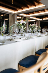Decorated table with fresh flowers and serving with postcard. Celebrating a party in a restaurant
