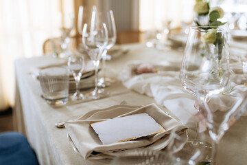 Decorated table with fresh flowers and serving with postcard. Celebrating a party in a restaurant